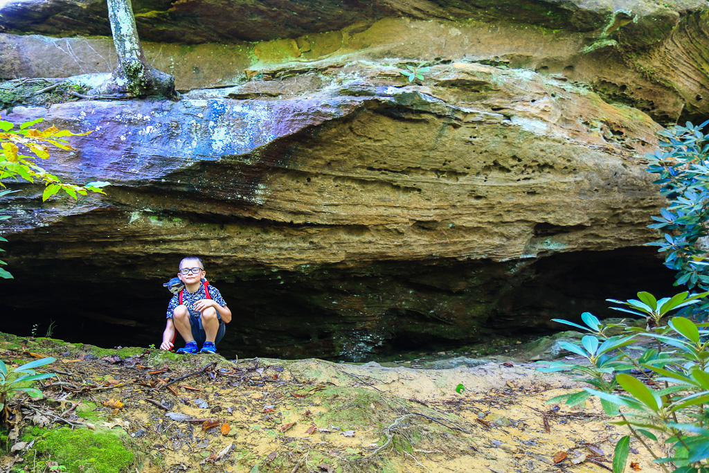 Cam exploring a recess cave - Auxier Ridge Trail
