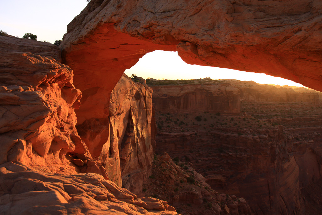 The sun reflecting off the canyon wall lights the underside of the arch - Mesa Arch